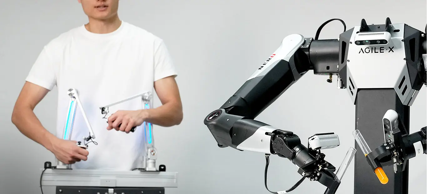 Universal Master Arm - stanowisko teleoperacji: operator z dwoma ramionami wiodącymi steruje robotem dwuramiennym