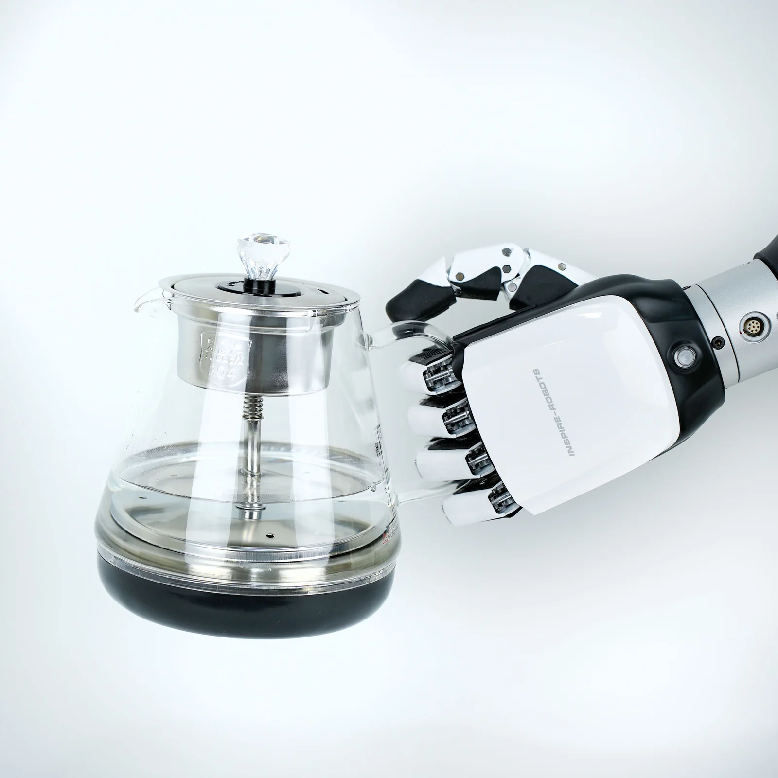 Dłoń RH56E2 na ramieniu robota trzyma szklany czajnik za uchwyt (zdjęcie producenta)